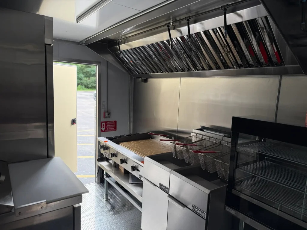 inside of a food trailer with griddle hot plate fryers hood fire suppression and refrigeration